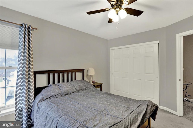 carpeted bedroom featuring ceiling fan and a closet