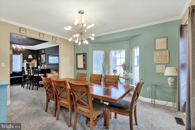 carpeted dining room with ornamental molding and a notable chandelier