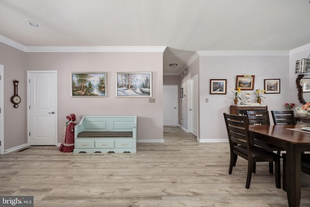 dining area featuring light hardwood / wood-style floors and crown molding