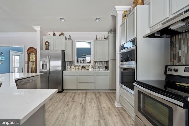 kitchen with ornamental molding, stainless steel appliances, a healthy amount of sunlight, and tasteful backsplash