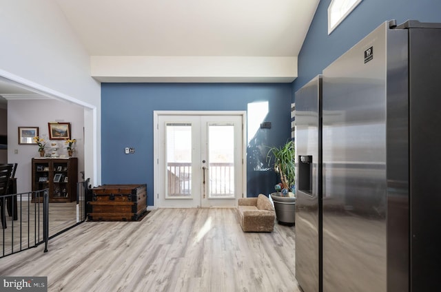 entrance foyer with light hardwood / wood-style flooring, french doors, and vaulted ceiling