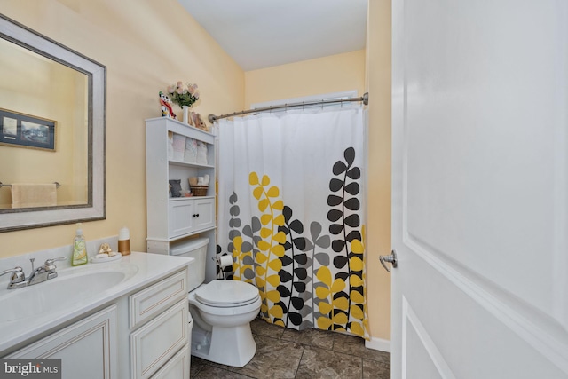 bathroom featuring toilet, a shower with shower curtain, and vanity