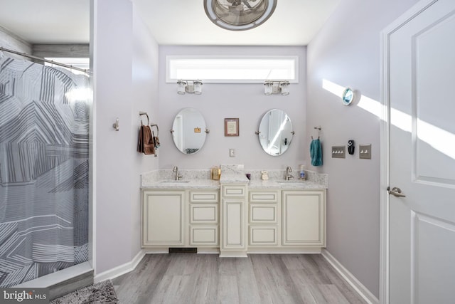 bathroom featuring hardwood / wood-style flooring, walk in shower, and vanity