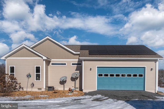 view of front of property featuring solar panels, central AC unit, and a garage