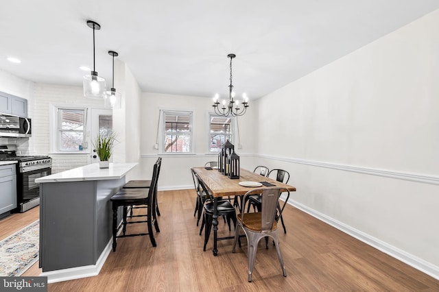 dining area featuring light hardwood / wood-style flooring and a chandelier