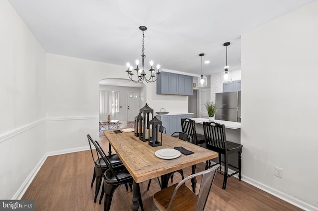 dining space with an inviting chandelier and dark wood-type flooring