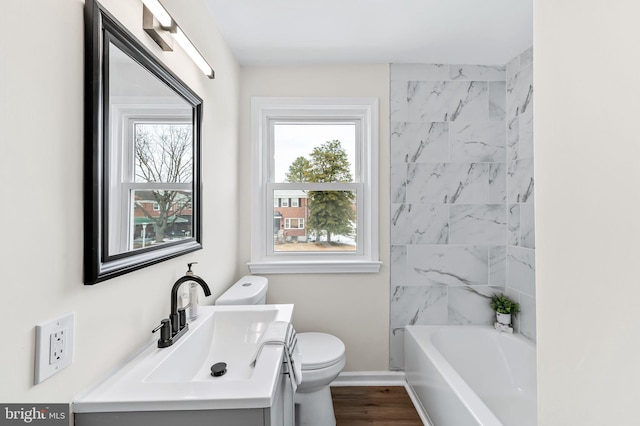 bathroom with a bathing tub, vanity, toilet, and wood-type flooring