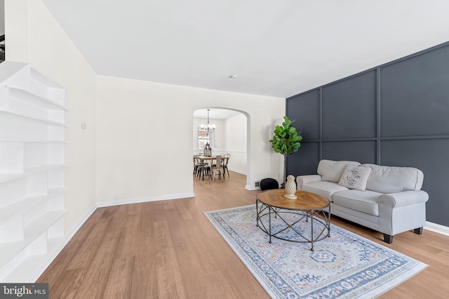 living room with a notable chandelier and light wood-type flooring