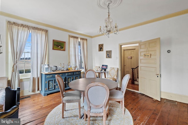 dining area with crown molding, a chandelier, and light wood-type flooring