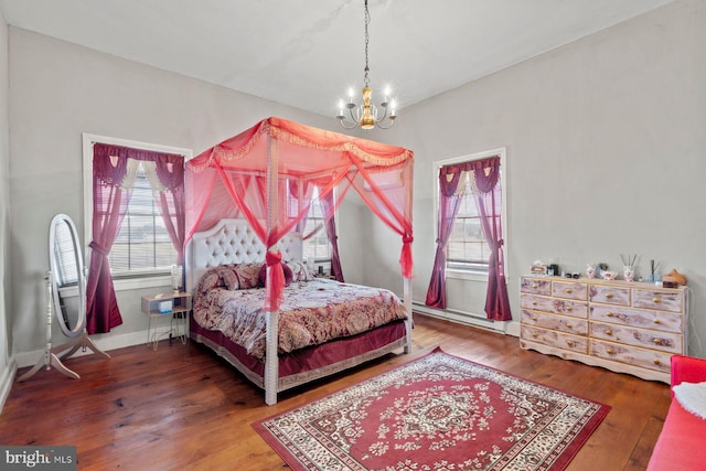 bedroom featuring hardwood / wood-style flooring, a baseboard radiator, and a notable chandelier