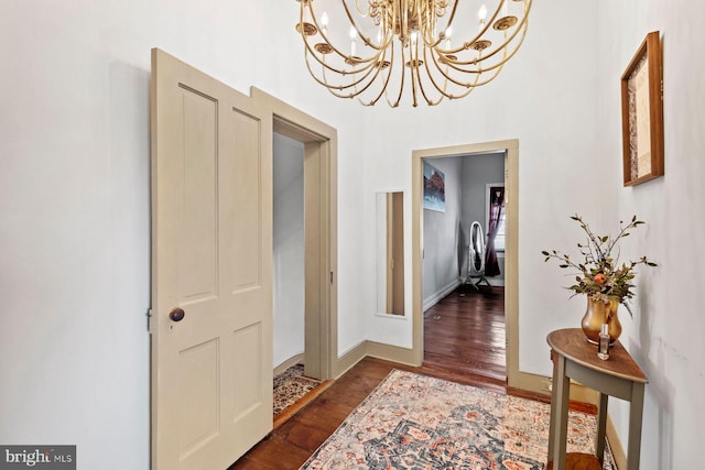 hallway featuring a notable chandelier and dark hardwood / wood-style floors