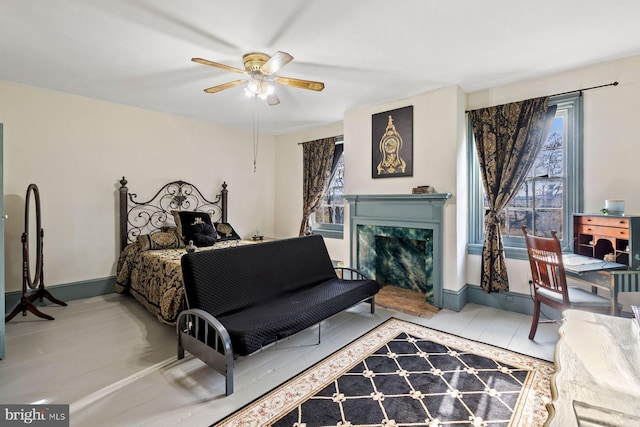 bedroom with ceiling fan and a premium fireplace