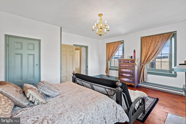 bedroom featuring dark hardwood / wood-style flooring, baseboard heating, and a notable chandelier