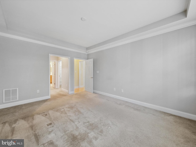 carpeted empty room featuring crown molding