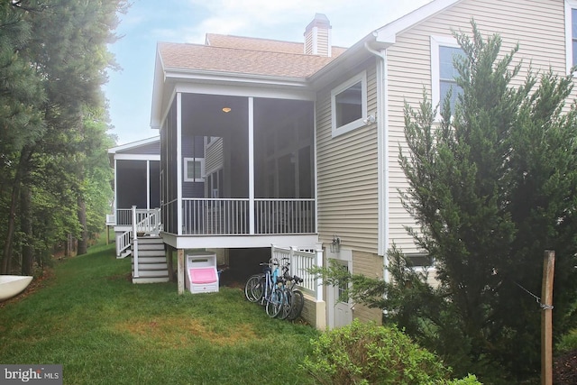 back of house featuring a yard and a sunroom