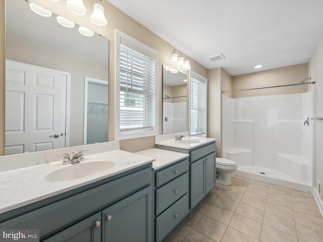 bathroom featuring toilet, vanity, tile patterned floors, and walk in shower