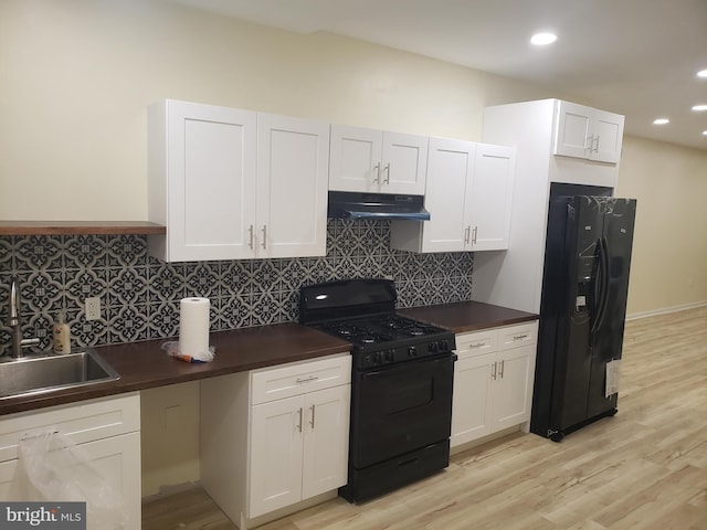 kitchen with tasteful backsplash, sink, black appliances, light hardwood / wood-style flooring, and white cabinetry