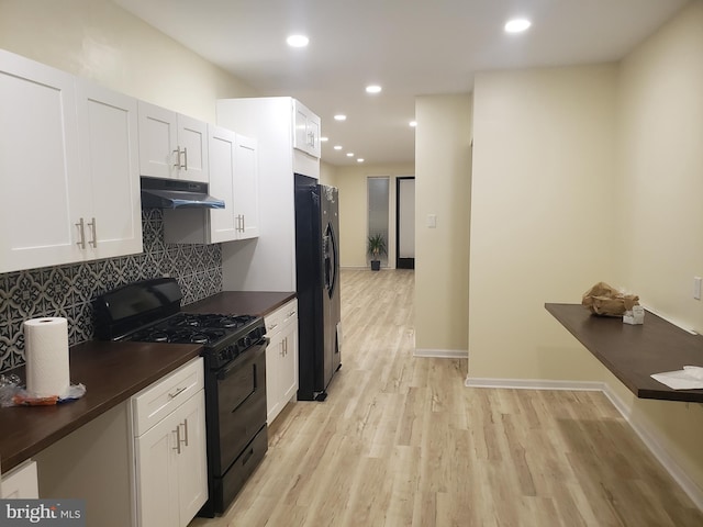 kitchen with decorative backsplash, light wood-type flooring, white cabinetry, and black appliances