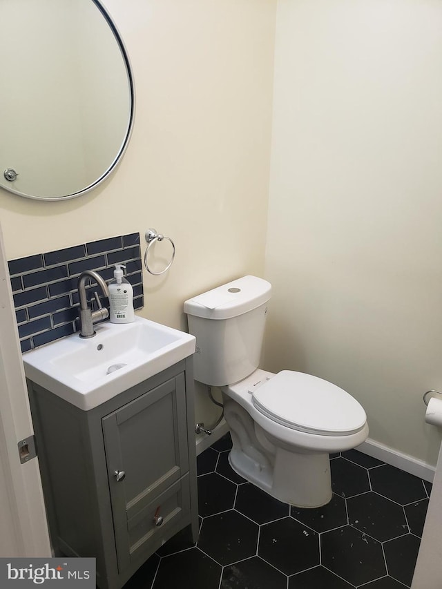 bathroom featuring decorative backsplash, vanity, and toilet