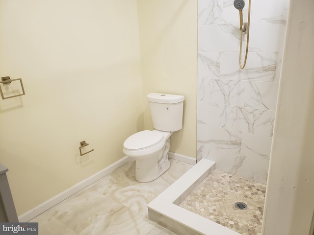 bathroom with tiled shower and toilet