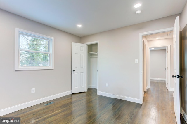 unfurnished bedroom featuring a closet and dark wood-type flooring