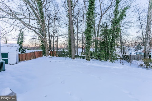 yard layered in snow with a storage shed