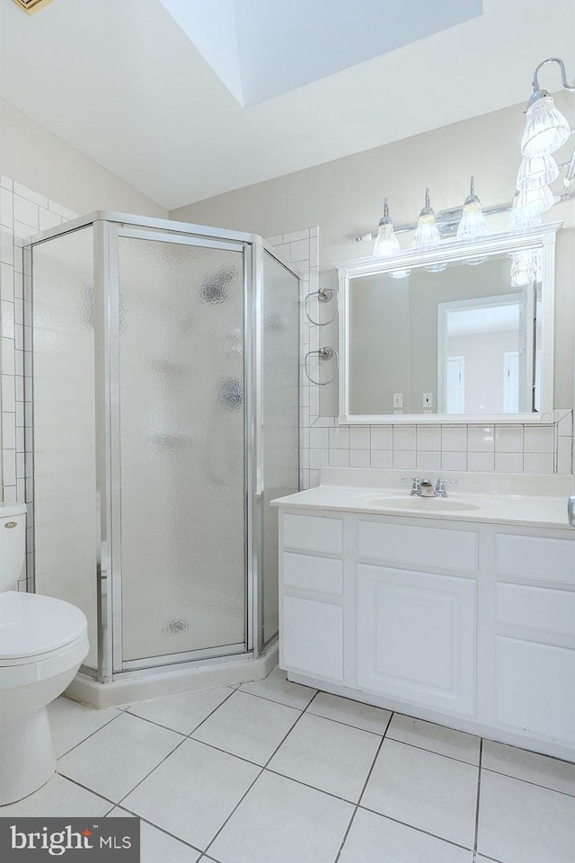 bathroom with a shower with door, tile patterned floors, and vanity