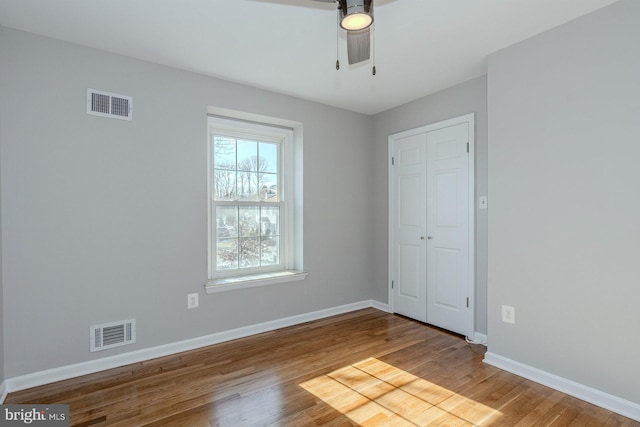 empty room with ceiling fan and hardwood / wood-style floors