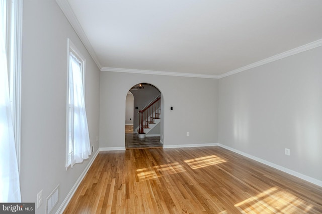 empty room featuring hardwood / wood-style flooring and ornamental molding