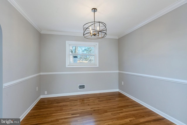 unfurnished dining area featuring ornamental molding, a chandelier, and hardwood / wood-style floors