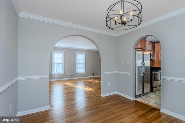 unfurnished dining area with crown molding, a chandelier, and light hardwood / wood-style flooring