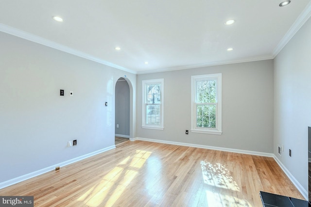 empty room featuring light wood-type flooring and crown molding