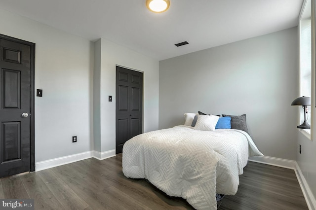 bedroom with a closet and dark wood-type flooring