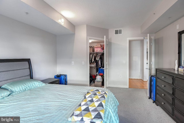 bedroom featuring a spacious closet, a closet, and light carpet