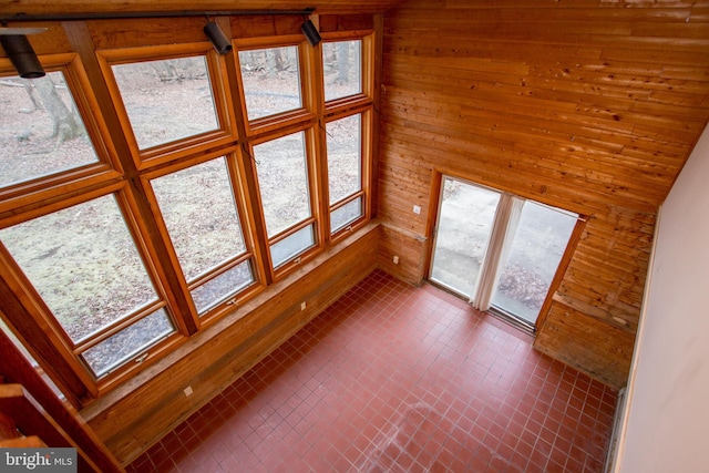 unfurnished living room with wood walls