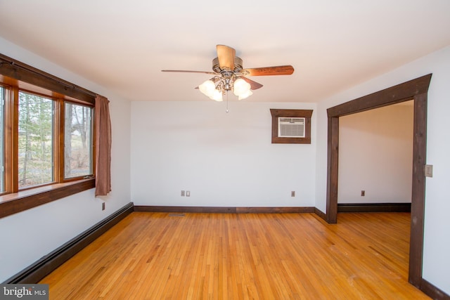 unfurnished room with baseboard heating, a wall mounted AC, ceiling fan, and light wood-type flooring