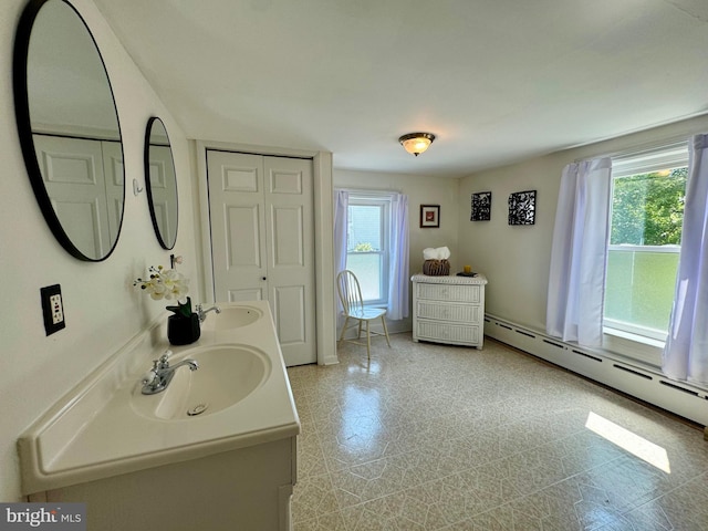 bathroom featuring plenty of natural light, vanity, and a baseboard radiator