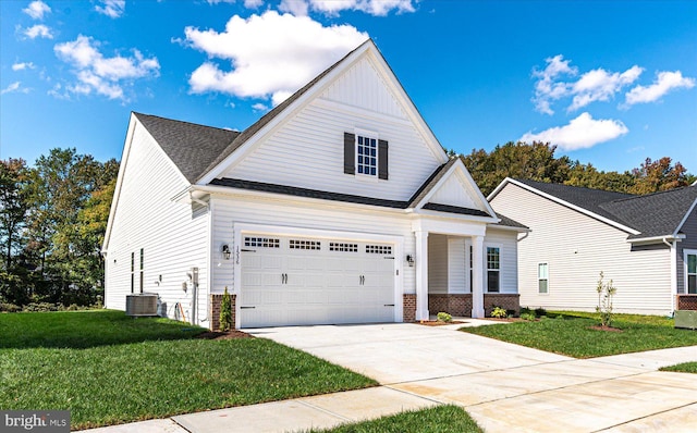 view of front of home with central AC unit, a garage, and a front yard