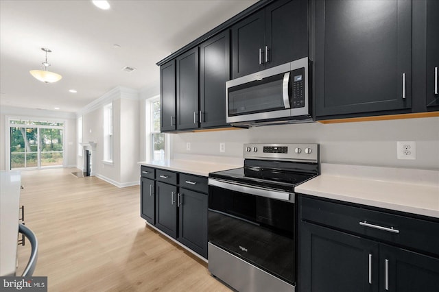 kitchen with decorative light fixtures, stainless steel appliances, a wealth of natural light, and light hardwood / wood-style floors