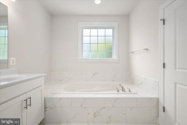 bathroom with vanity and a relaxing tiled tub