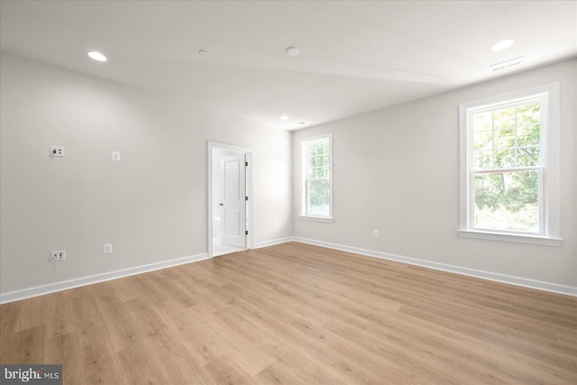 empty room with light hardwood / wood-style floors and a wealth of natural light