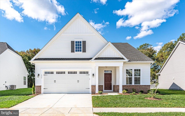 view of front of house with a garage, central air condition unit, and a front yard