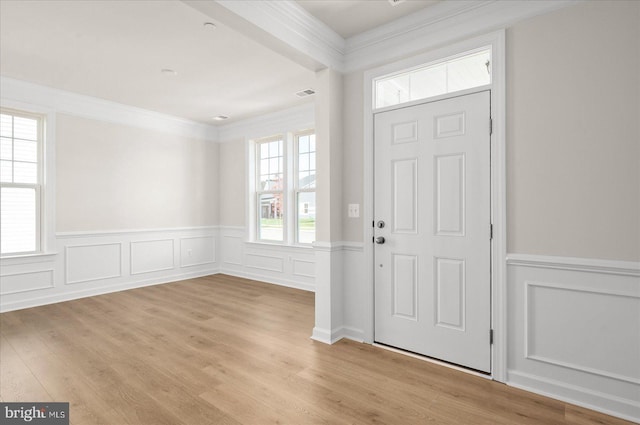 foyer entrance with light wood-type flooring and ornamental molding