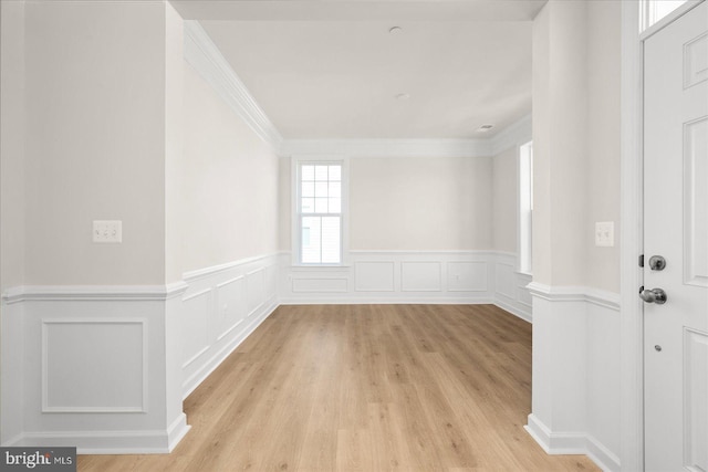 empty room featuring crown molding and light wood-type flooring