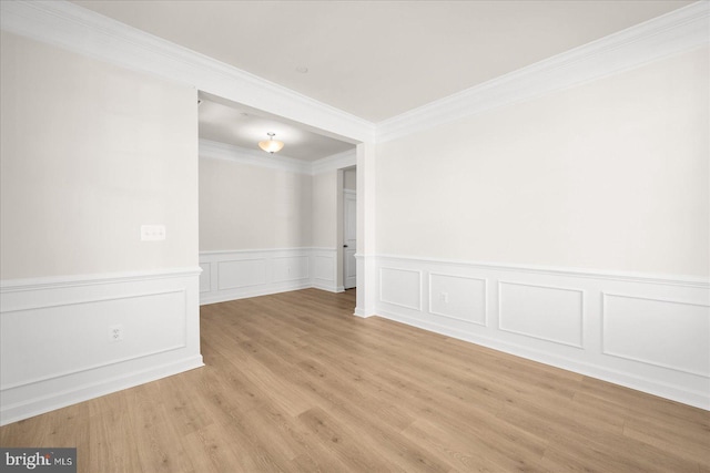 spare room with crown molding and light hardwood / wood-style floors