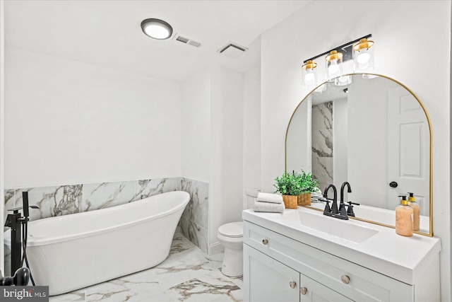 bathroom featuring a bathing tub, vanity, and toilet