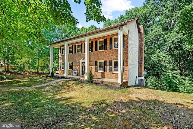 view of front of house featuring central air condition unit and a front yard