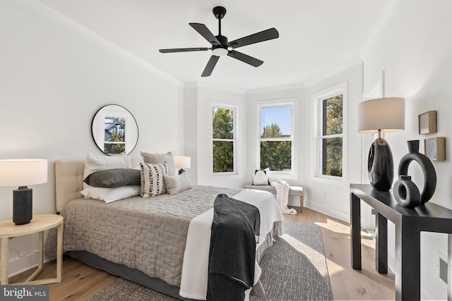 bedroom featuring ceiling fan, light hardwood / wood-style flooring, and crown molding