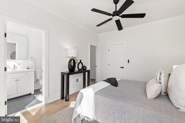 bedroom with light wood-type flooring, ensuite bath, ceiling fan, crown molding, and sink