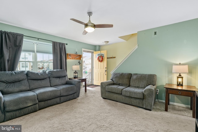 carpeted living room with ceiling fan